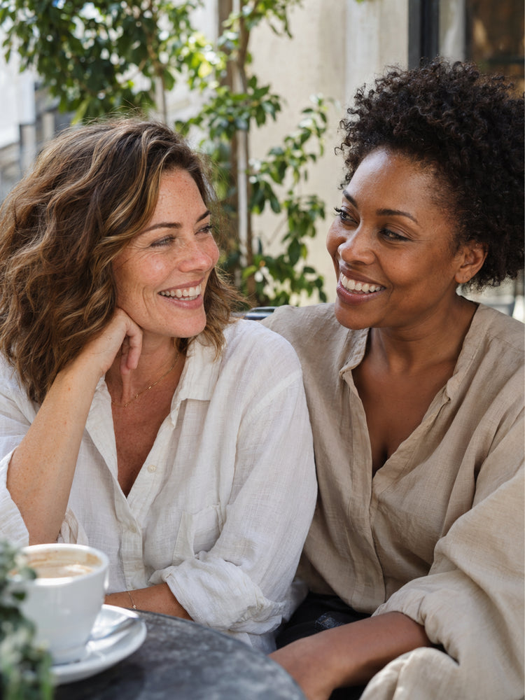 Two friends laughing together at a cafe